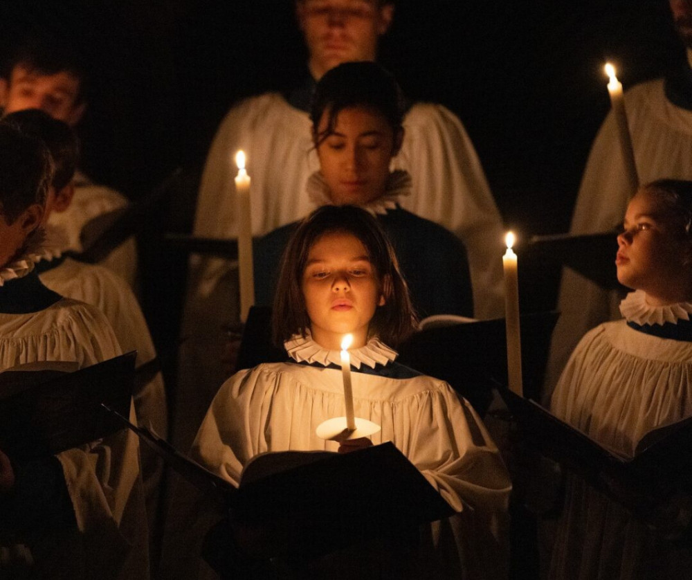 Wells Cathedral illuminated by candlelight during a festive Carols by Candlelight service.