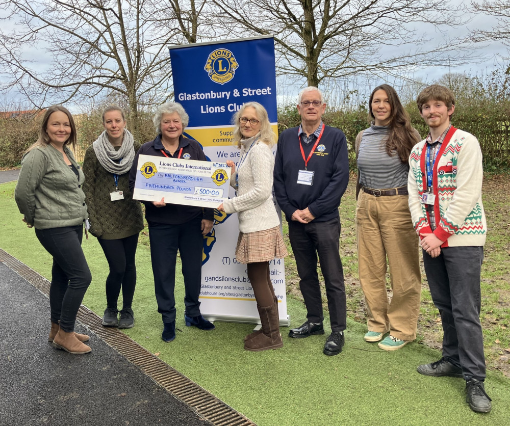 Lions Ronnie Harkness and Chris Ford presenting a cheque to members of staff at the school