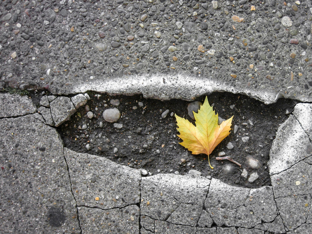 A pothole on a residential road (Unsplash) 