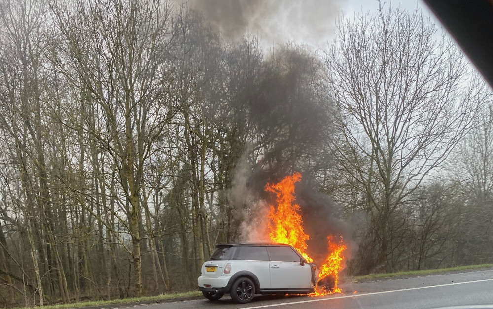 The BMW mini fully alight on the hard shoulder of the M40 (image supplied)