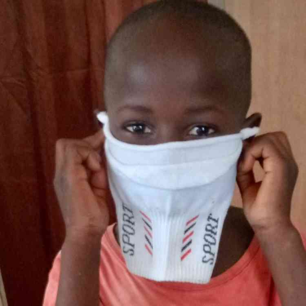 Young Gambian boy with makeshift mask made from sock