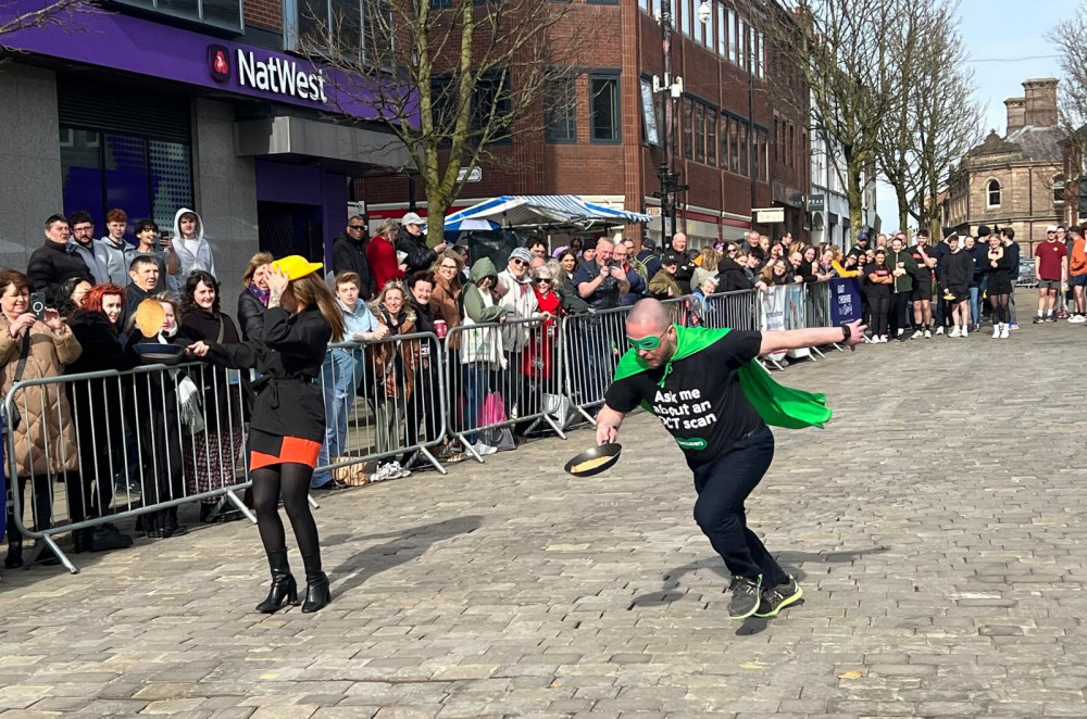 A team of Bridget Jones' take on the Specsavers crew at the 2025 Macclesfield Pancake Race (Credit: Nub News)