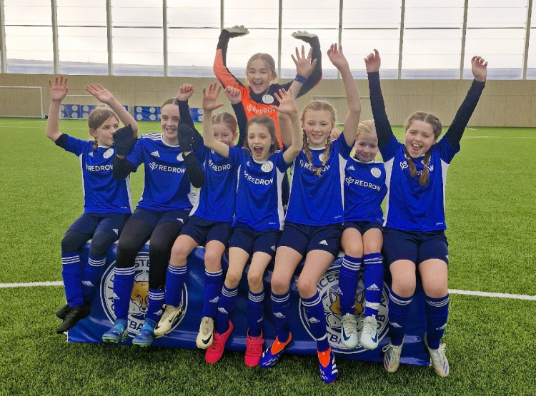 Members of the Whitwick St John Baptist School girls' football team celebrating their new kits