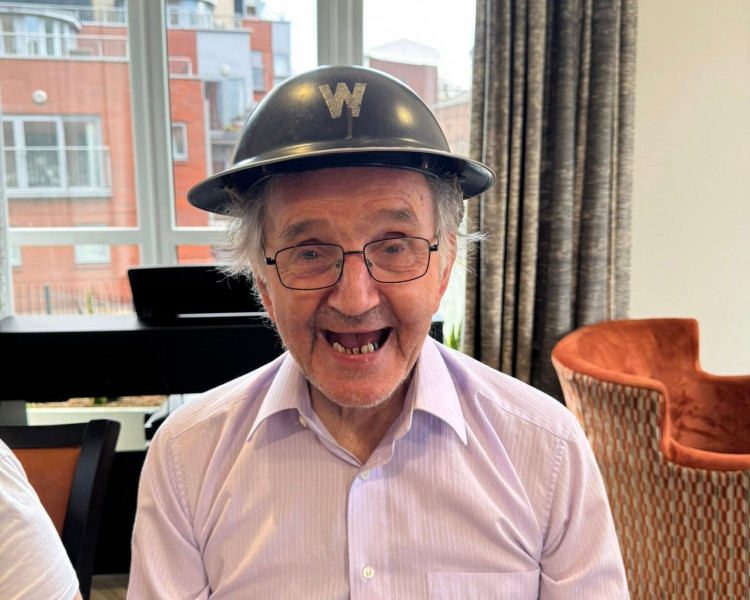 Bill Jones tries on a British Army Brodie helmet (Image via: Belong)