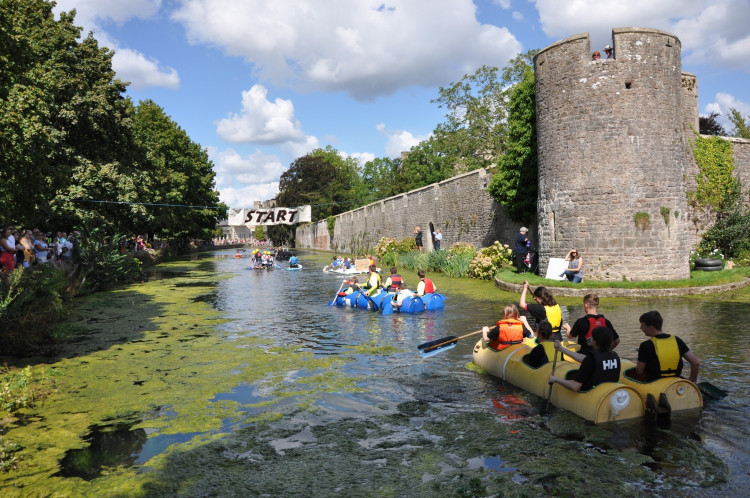 Crews battle it out on the Bishop’s Palace moat during a previous Wells Moat Boat Race – paddles, pride and plenty of splashes on the line.