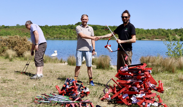 L-R Geoff Walker, chair of W.I.L.E Wombles in Litter Education, Sam Laywood, Leicester Wombles and Tom Burton, National Forest community ranger receiving kit donation at Albert Village Lake. Photo: National Forest Company