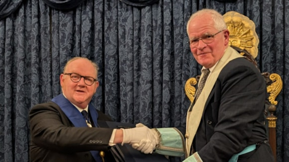 Simon Medland presenting the restored Crane Manuscripts to Tim Dutton, the master of Cestrian Lodge (Image via: Cestrian Lodge)