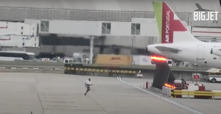 Footage from Big Jet TV shows a man sprinting across a Heathrow taxiway before being detained by airport staff and police. Flights were unaffected (credit: YouTube/Big Jet TV).