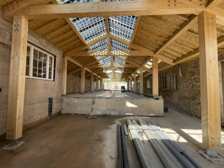 Glastonbury unveils St Dunstan’s House atrium, revealing bold Community Health Centre designs with solar-paneled glass roof. 