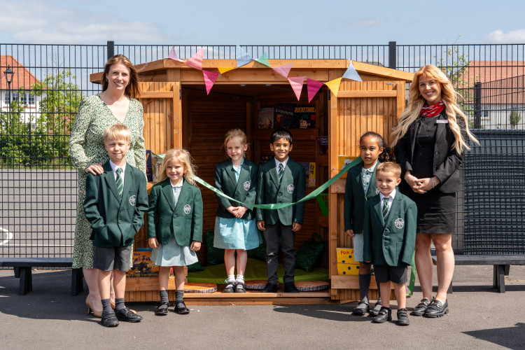 Headteacher Mrs E Drake and Redrow's Shanice Williams with students from Woodford Primary School (Image supplied)