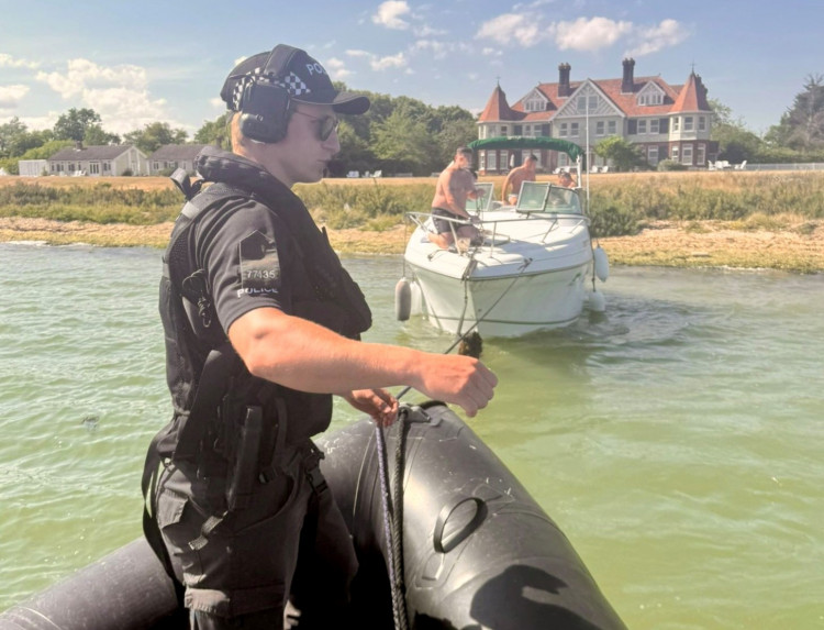 Officers assist in recovering a boat nearby to what appears to be Osea Island. (Credit: Essex Police)