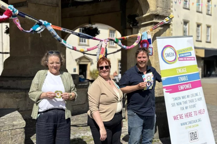 A scarf around Shepton Mallet's Market Cross raises awareness and funds for SWEDA. (Supplied) 