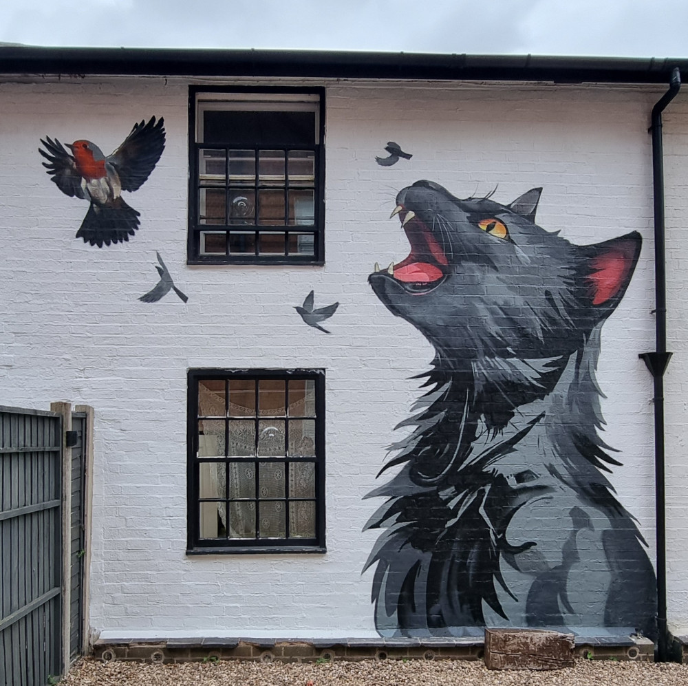 The work, created by Brink Contemporary Arts, entitled 'Rebecca', depicts a scruffy cat, mouth wide open, releasing the birds she has caught throughout her life (image via Tim Robottom) 