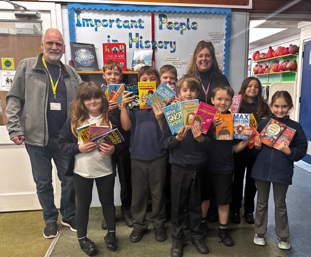 Kevin Phillimore from Wells Rotary and teacher Liz Ramsay and some of the children with books they were given