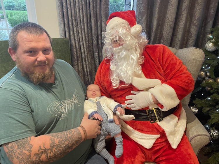 Crandon Springs resident Archie’s 10-week-old great grandson posed for his first photo with Santa, cradled by his dad Wayne.