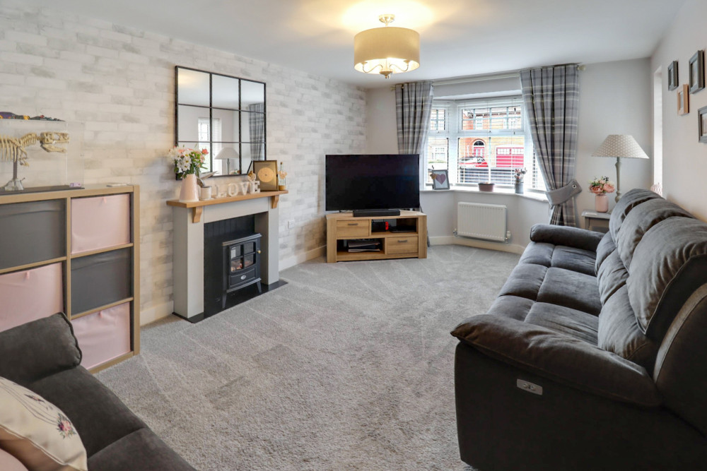 Bright and welcoming living room with feature fireplace and elegant bay window filling the space with natural light