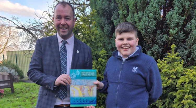 Cllr Mark Roberts with artist Clayton, holding the design for Stockport Council's 2025 Christmas cards (Image - Stockport Council)