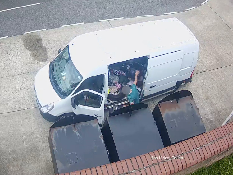 A thief loads stolen items into his van.