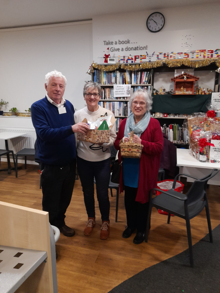 Trustee Cllr Chris Franks being offered packets of chocolate from event organisers Liz and Jill.
