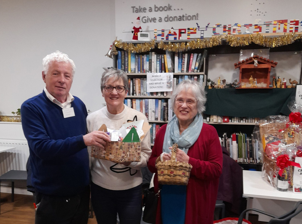 Trustee Cllr Chris Franks being offered packets of chocolate from event organisers Liz and Jill.