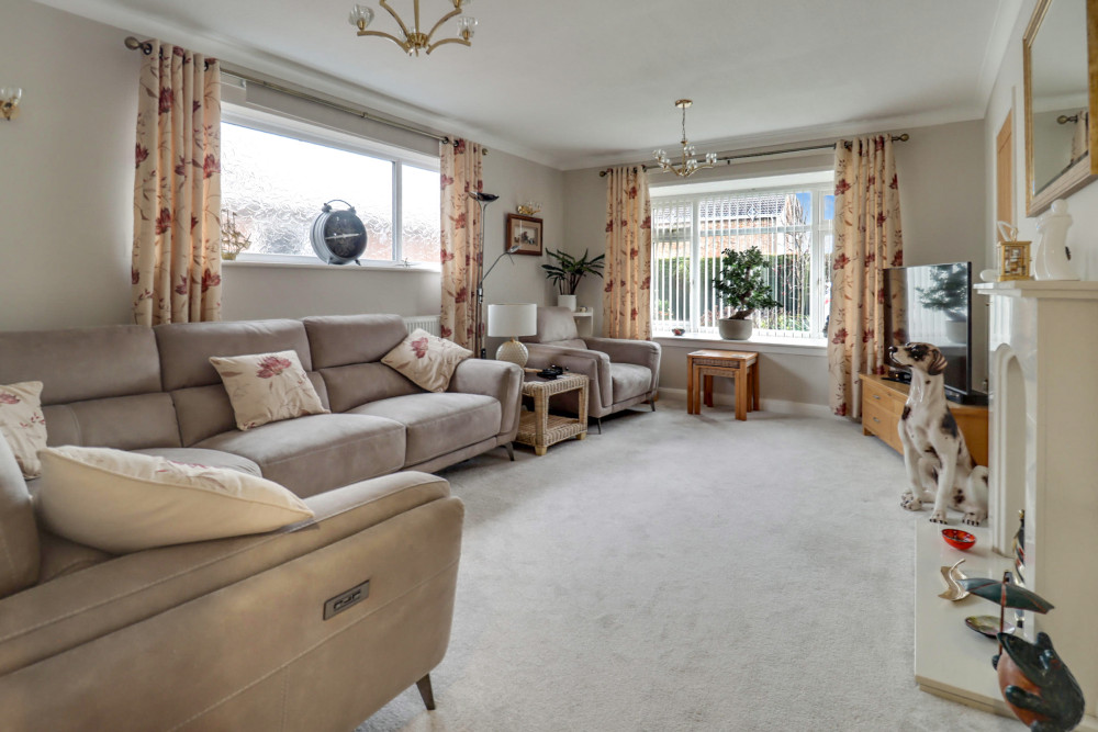 Generous living room featuring a charming bay window and fireplace, creating a bright and inviting space to unwind