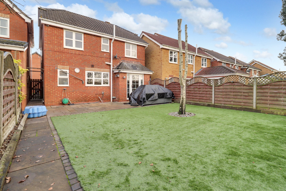 A low-maintenance, south-facing rear garden with patio seating and astro turf, perfect for enjoying the sun with minimal upkeep
