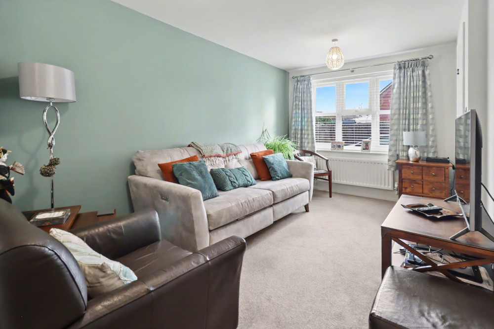 Bright and welcoming living room with useful under-stairs storage, offering a cosy space to relax and unwind