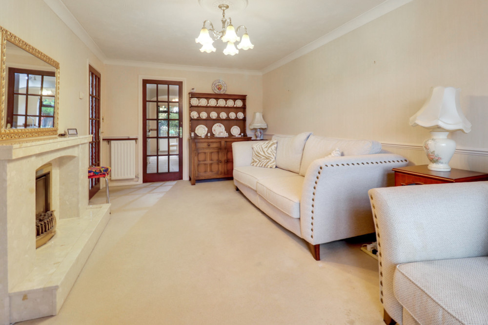 Bright and spacious lounge with feature fireplace and large bow window creating a warm, airy feel