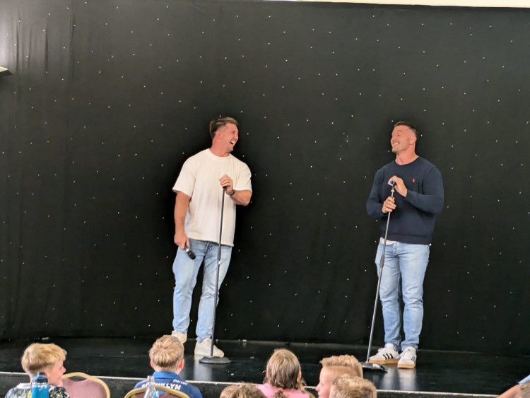 Twins, Tom and Ben Curry, who attended Sandbach School briefly and also played cricket at Elworth Cricket Club, popped into Bradwall Bakehouse and Coffee Shop recently. They are seen on stage here at a previous event in Sandbach. (Photo: Nub News) 