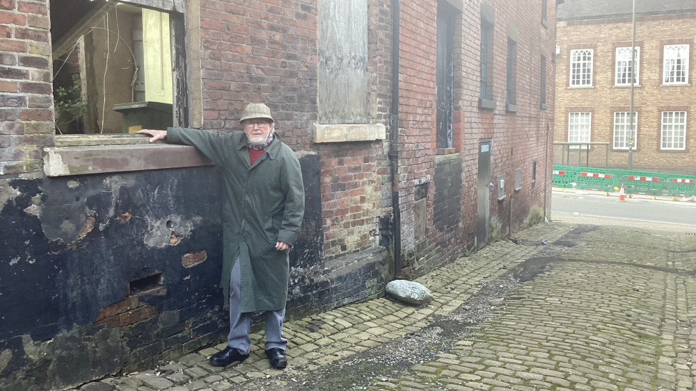 Roger Warrilow, chair of Leek & District Civic Society, outside the derelict Grade II listed former warehouse in Silk Street, Leek (image via Roger Warrilow)