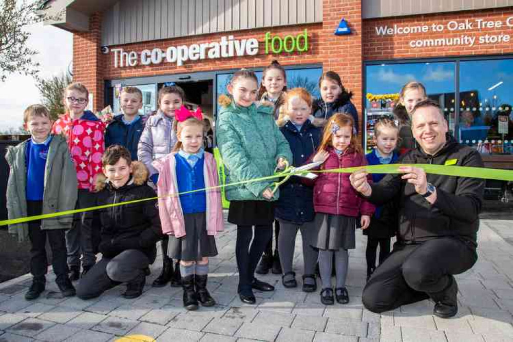 Central England Co-op store manager Jonathan Bird cuts the ribbon with youngsters from Hugglescote Community Primary Centre to open the new Oak Tree Corner Community Food Store.  