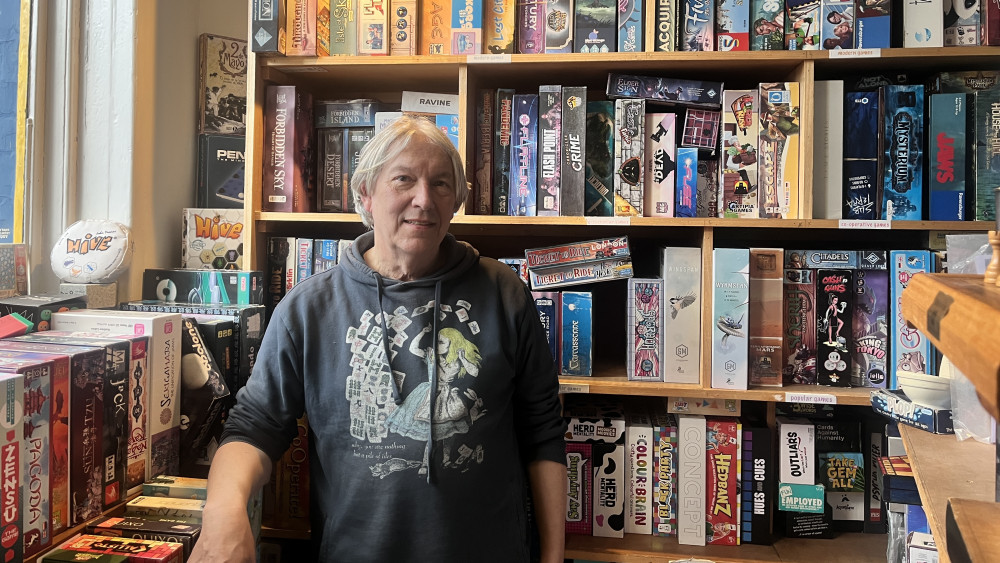 Rob Cormican in front of his catalogue of board games at the Library Pot on Kew Road, Richmond (credit: Nub News).