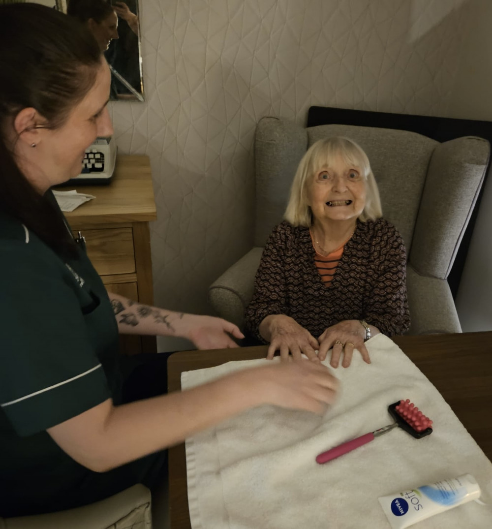Crandon Springs resident Christine, enjoying her hand massage spa experience with carer Liza.
