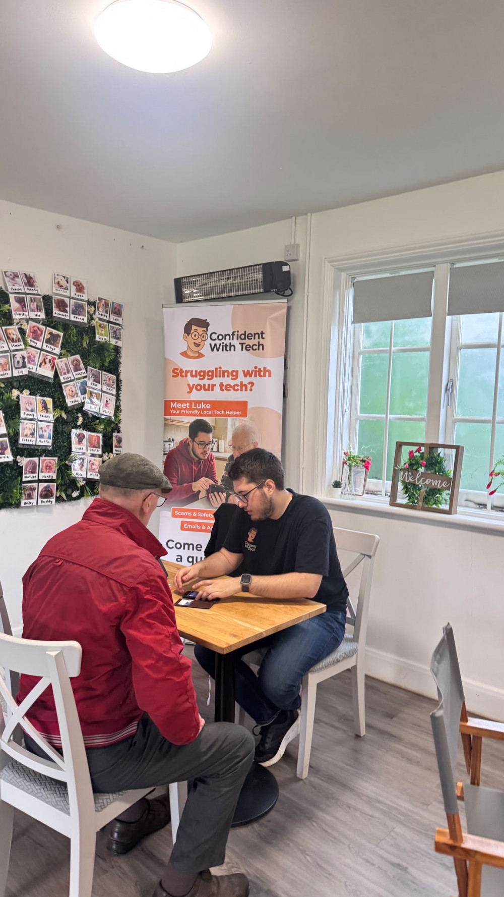 Luke Vincent from Confident With Tech helps a local resident with their phone during the free tech clinic at Fairfield Pavilion Cafe.