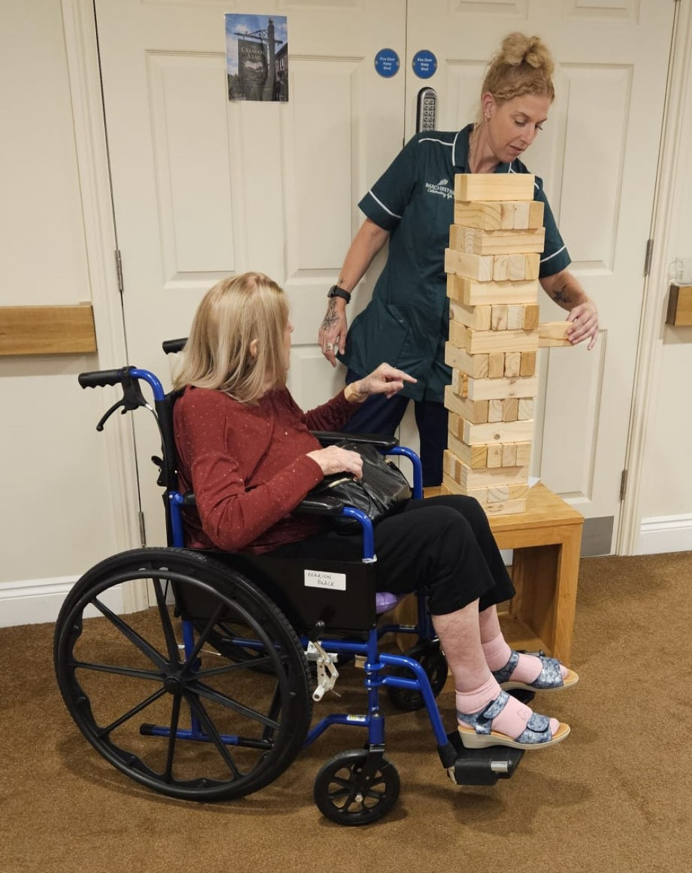 Resident Marion tries her hand at a game of giant Jenga with carer Zoe at the Crandon Springs Care Home pop-up pub event.