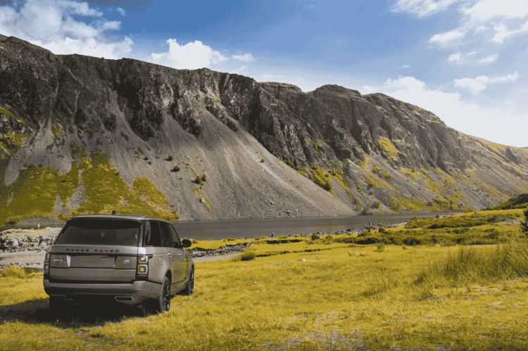 A Land Rover winds through stunning mountain scenery, proving that sometimes the journey is every bit as memorable as the destination