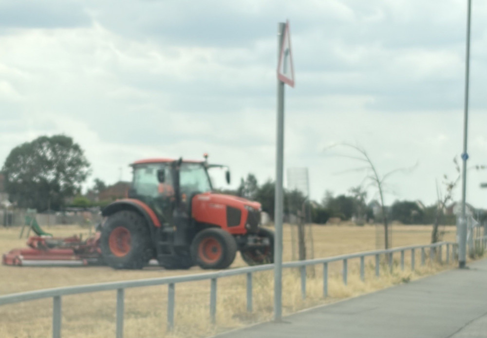 The council tractor and mowing equipment in action adjacent to Orsett Heath Crescent. 