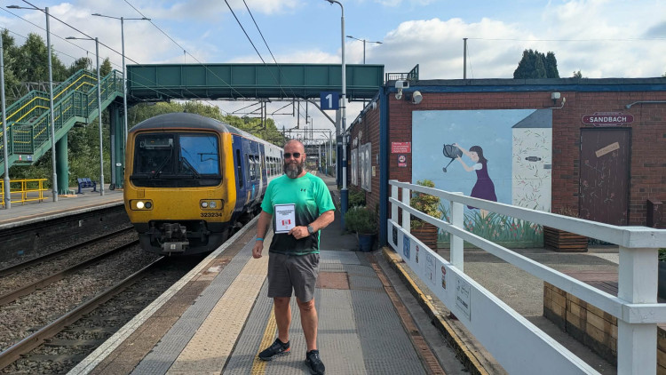Colin Storey holding a flyer for his petition and one side of the steps showing across from the bridge for passengers using platform two on the Manchester Piccadilly line. (Photo: Nub News)    