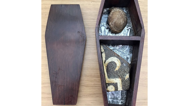 Glastonbury Abbey has welcomed back a medieval kneecap and floor tile fragment after a 70-year absence and a 50-year detour to Australia.