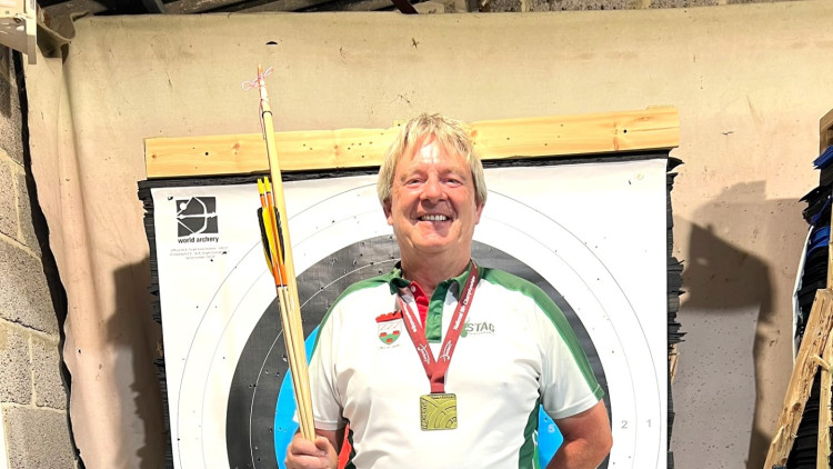 Richard Gregory with his Longbow and medal