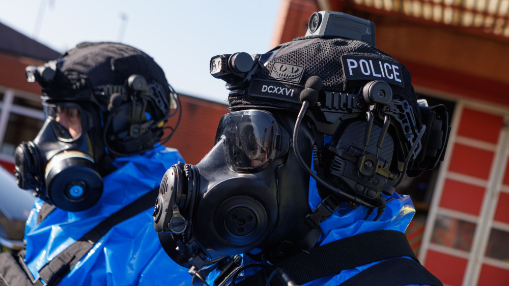 Police in protective equipment enter the premises on Gordon Street in Heaton Norris (Image - GMP)