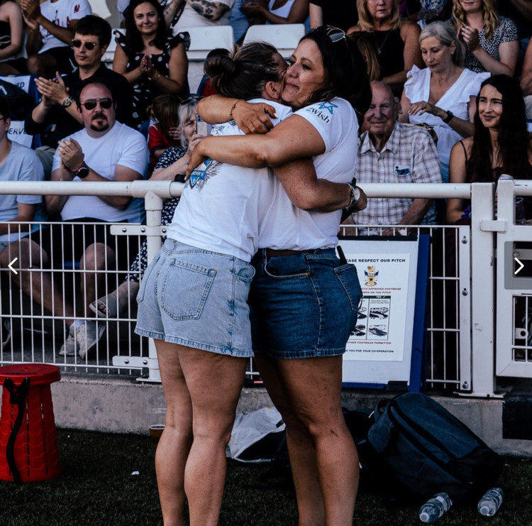 Lucy Ross and Kelly Hatchard hug each other at a recent footballing tribute to Henry held in Aveley. 
