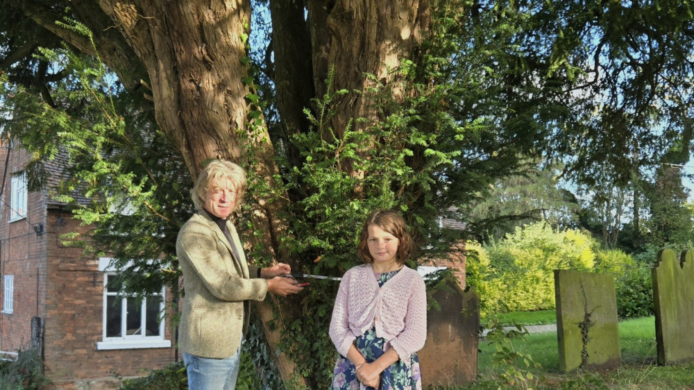 Stafford Borough Cllr Scott Spencer and Pippa Simmons measure a 400 year old yew tree in the grounds of Gnosall St Lawrence Church (image via Chris Haycock)