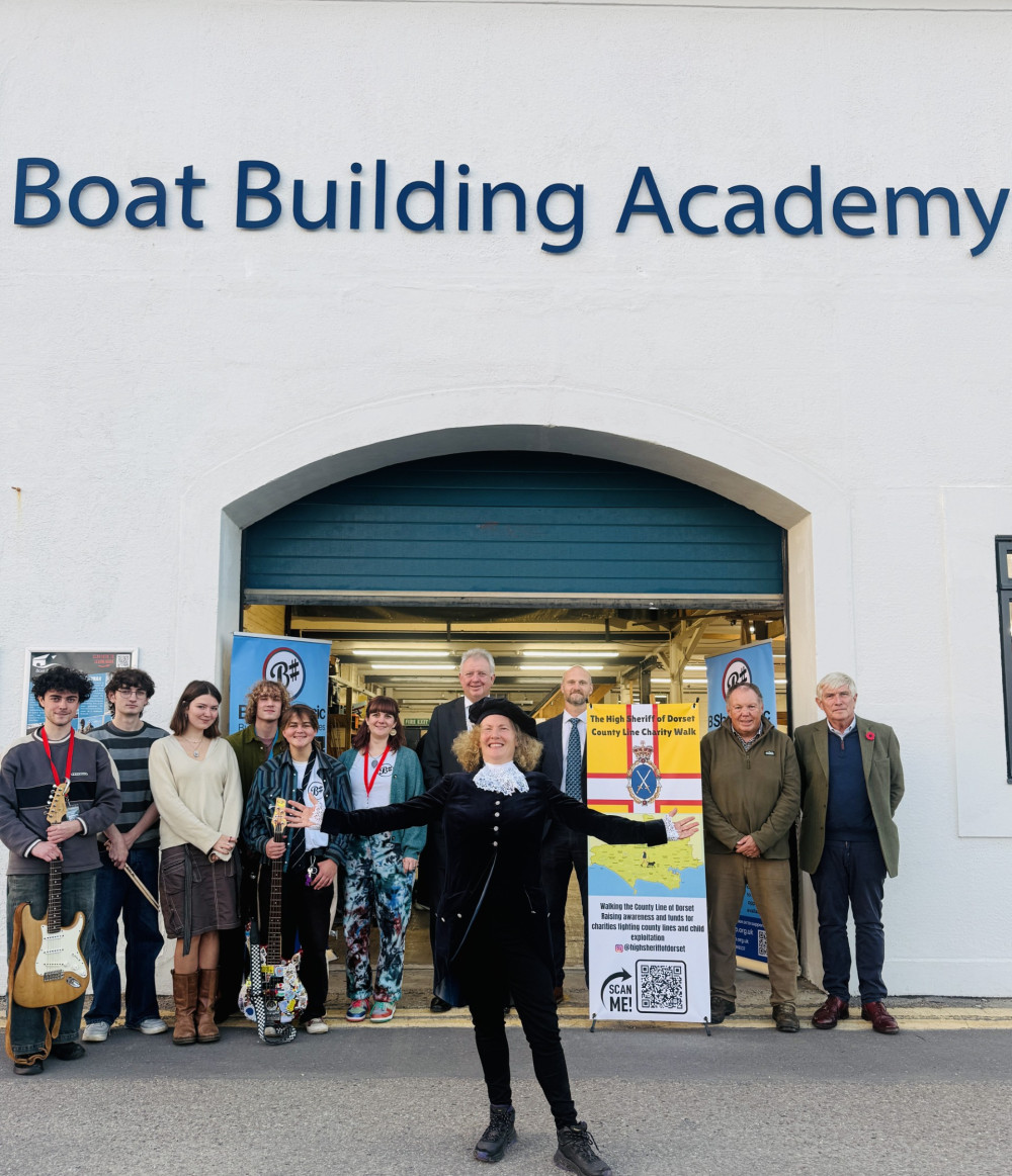 The High Sheriff of Dorset Helena Conibear (centre) completed her 200- mile walk highlighting county lines and child exploitation at the Boat Building Academy in Lyme Regis. She was greeted at the finish by around 80 local dignitaries, supporters, young people, and well-wishers.