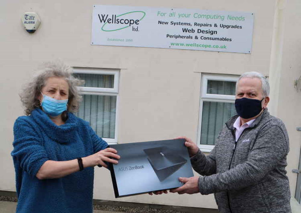 Former Wells city councillor Chloe Rees presents her laptop to Richard Boulos for data removal