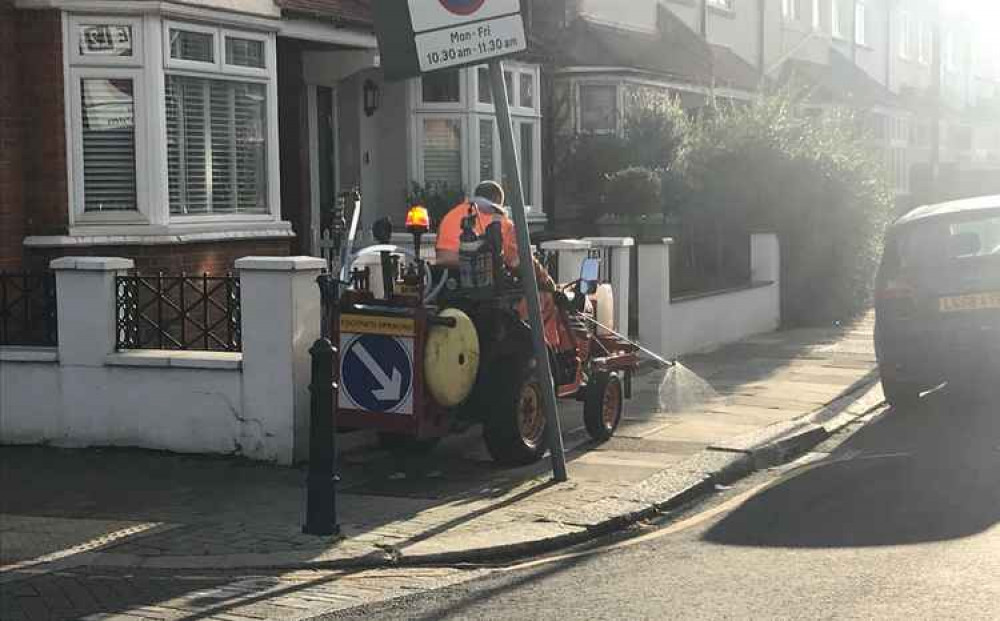 Council workers spraying Roundup pesticide on a pavement in Wandsworth